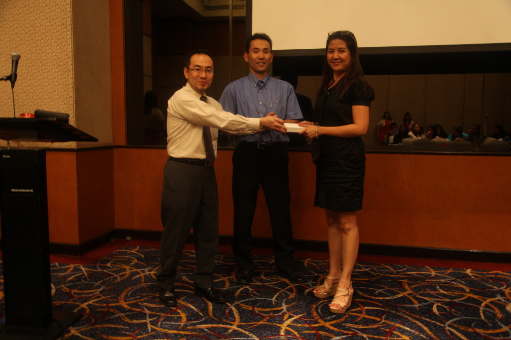 Ichimaru awarding the iPod to Ms. Marissa Marable of Ysa Skin Care.